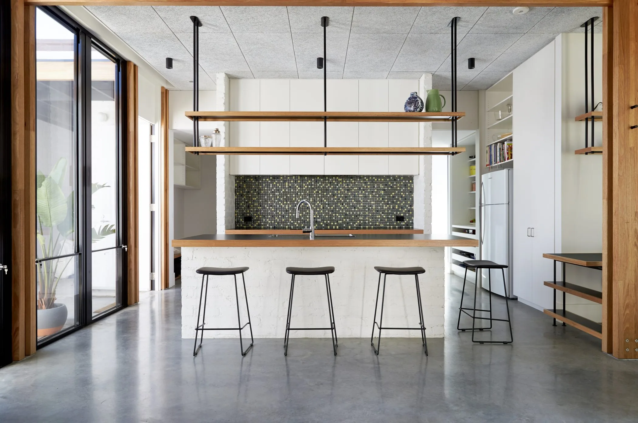 Ballantyne kitchen showing the brick island bench and acoustic ceiling panels in this extended home in Thornbury, Melbourne